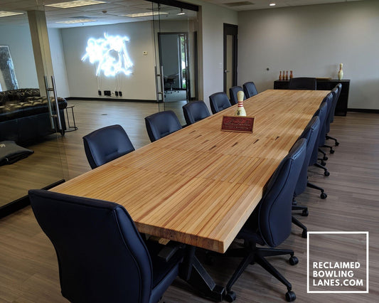 board room table made from reclaimed bowling lane on industrial trestle base